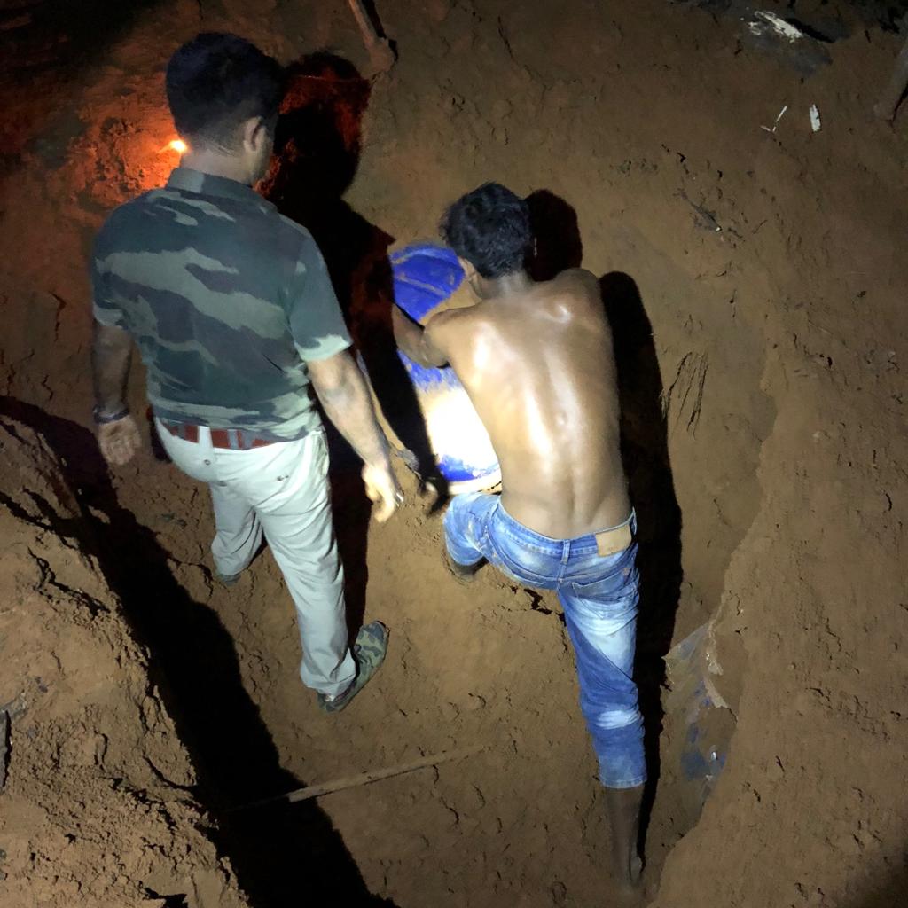 Police pulling out ganja drums from pits
